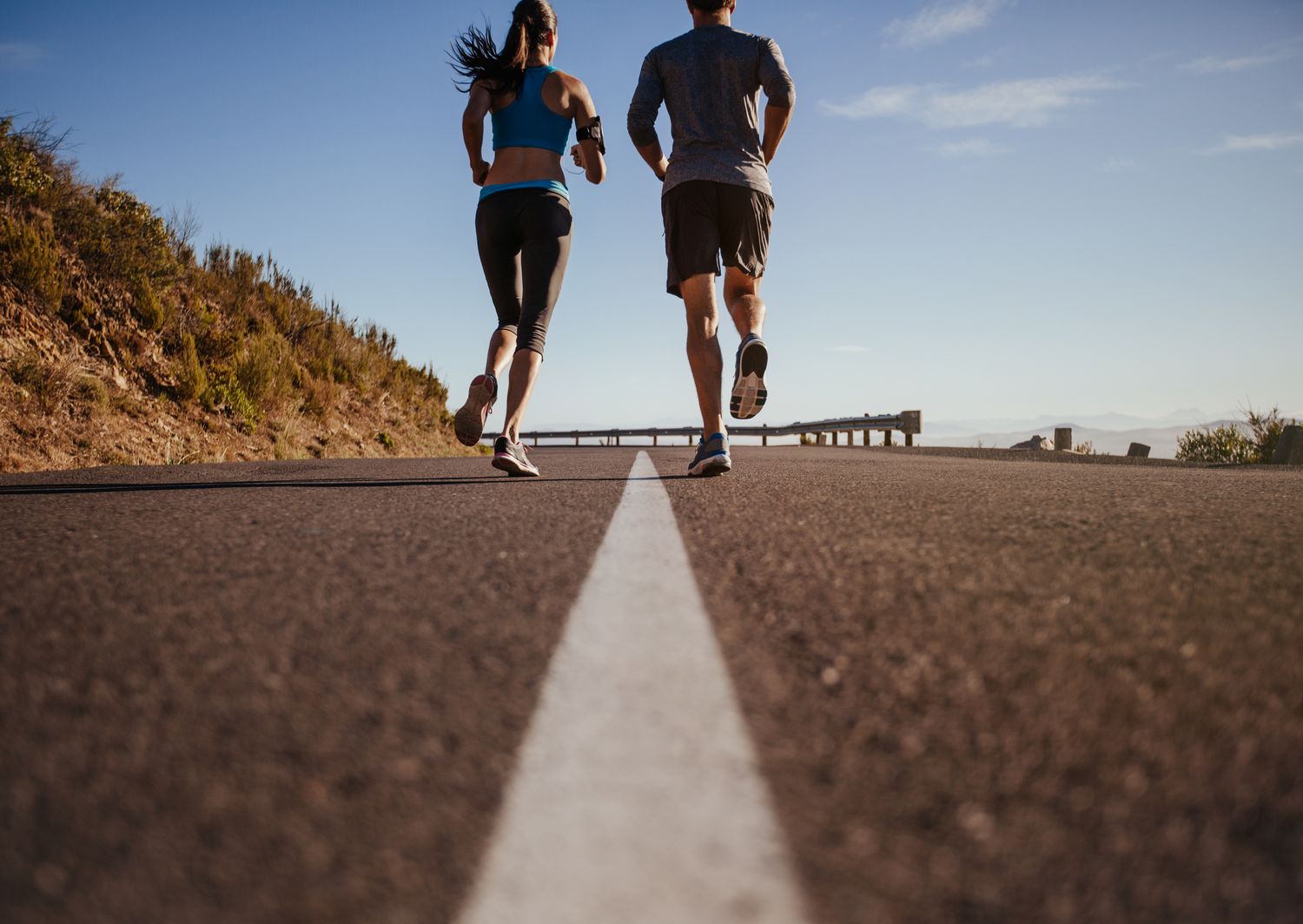 man and woman running on road